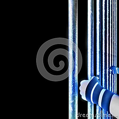 Detention, imprisonment. Prison cell and hands holding the bars Stock Photo