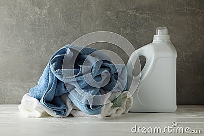 Detergent and crumpled towels against gray background Stock Photo