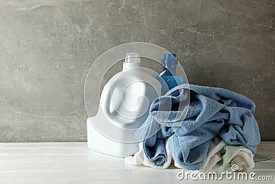 Detergent and crumpled towels against gray background Stock Photo