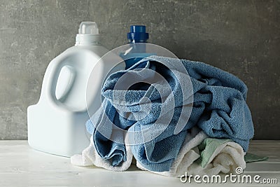 Detergent and crumpled towels against gray background Stock Photo