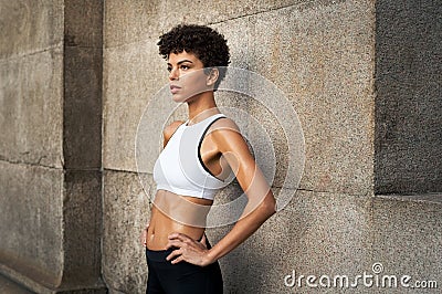 Determinated sporty woman resting on wall Stock Photo