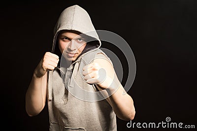 Determined angry young boxer in a hooded top Stock Photo