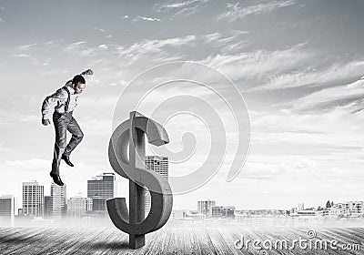 Determined banker man against modern cityscape breaking dollar concrete figure Stock Photo