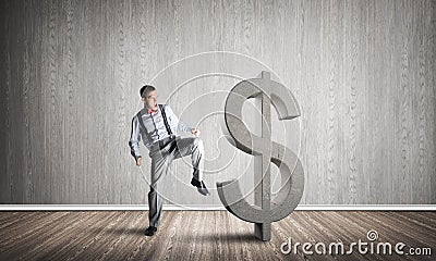 Determined banker man in empty concrete room breaking dollar figure Stock Photo