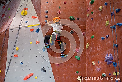 Determined boy practicing rock climbing Stock Photo