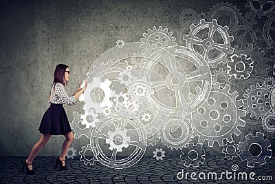 Determined business woman pushing gears Stock Photo