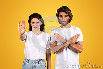 Determined woman with an outstretched hand signaling stop and a serious man with arms crossed in an X Stock Photo