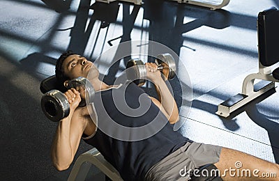 Determined Exercising With Dumbbells In Club Stock Photo