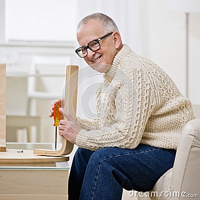 Determined man constructing wooden table Stock Photo