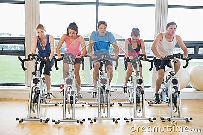 Determined people working out at spinning class in gym Stock Photo