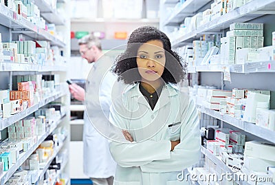 Determined to do whats best for your wellness. Portrait of a confident young woman working in a pharmacy with her Stock Photo