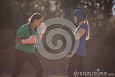 Determined women practicing boxing during obstacle course Stock Photo