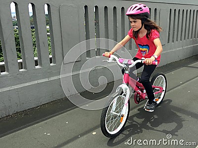 Determined young girl rides a bike Stock Photo