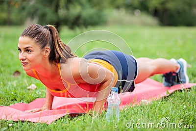 Determined young woman holding plank position on exercise mat Stock Photo