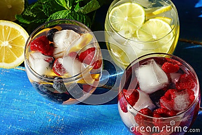 Detox cool drink with ice cubes and fresh raspberries, blueberries and fresh lemon Stock Photo
