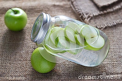 Detox diet fresh green apples soak in water of the jar on sack Stock Photo