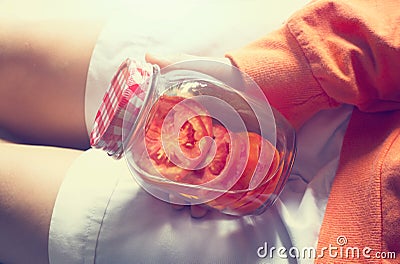 Detox diet fresh red tomato soak in water of the jar in woman hand Stock Photo