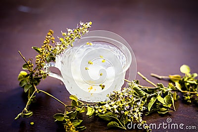 Detoxifying white ice tea in a transparent glass cup on wooden surface. Stock Photo