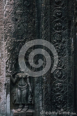 Devata sculpture without head in Ta Prohm temple at Angkor complex, Siem Reap, Cambodia Stock Photo