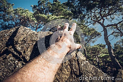 Development Attainment Motivation Career Growth Concept. Man`s hand clings to a rock. Concept of motivation, success, willpower Stock Photo