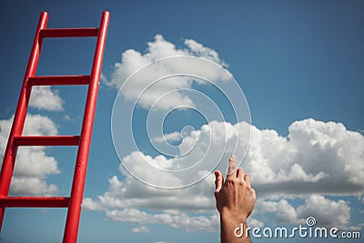 Development Attainment Motivation Career Growth Concept. Mans Hand Reaching For Red Ladder Leading To A Blue Sky Stock Photo