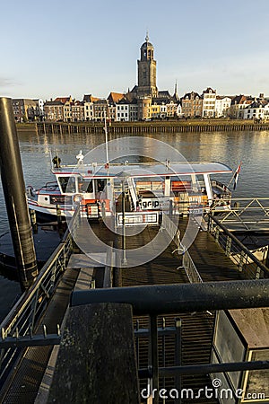 DEVENTER, NETHERLANDS - Dec 16, 2020: Deventer skyline with quay and ferry in the foreground Editorial Stock Photo