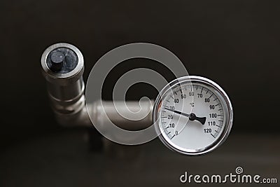 A device for measuring the temperature of water in the heating system. Pipe pressure relief valve. Stock Photo