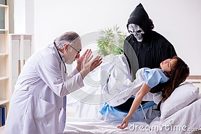 Devil, old doctor and female patient in the clinic Stock Photo