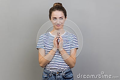 Devious woman clasping hands and smirking mysteriously, scheming cheats, evil prank. Stock Photo