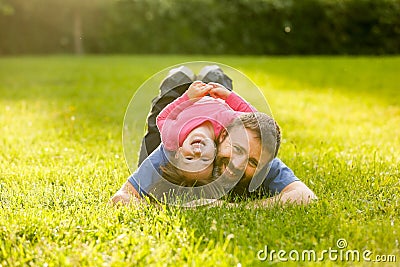Devoted father and daughter lying on grass Stock Photo
