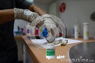 Dexamphetamine legal drug on the table with doctor wearing rubber safety glove conducting DNA urine test at the background Stock Photo