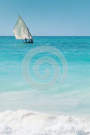 A dhow sailing off into the horizon on a blue sea Stock Photo