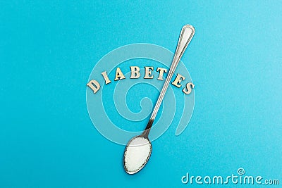 Diabetes inscription, spoon with sugar on a blue background Stock Photo