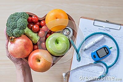 Diabetes monitor, Cholesterol diet and healthy food eating nutritional concept with clean fruits in nutritionist`s heart dish Stock Photo