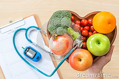 Diabetes monitor, Cholesterol diet and healthy food eating nutritional concept with clean fruits in nutritionist`s heart dish Stock Photo