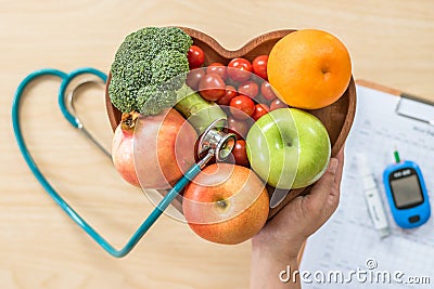 Diabetes monitor, Cholesterol diet and healthy food eating nutritional concept with clean fruits in nutritionist`s heart dish Stock Photo