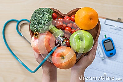 Diabetes monitor, Cholesterol diet and healthy food eating nutritional concept with clean fruits in nutritionist`s heart dish Stock Photo