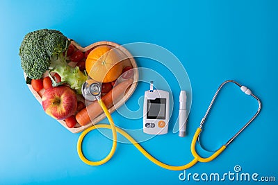 Diabetes monitor, diabetic measurement. World diabetes day concept with clean fruits in nutritionist`s heart dish..Healthy food or Stock Photo