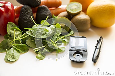 Diabetes monitor, diet and healthy food eating nutritional concept with clean fruits and vegetables with diabetic measuring tool Stock Photo