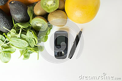 Diabetes monitor, diet and healthy food eating nutritional concept with clean fruits and vegetables with diabetic measuring tool Stock Photo