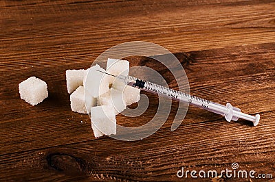 Diabetes is terrible disease. A lot of sugar cubes with syringe Stock Photo