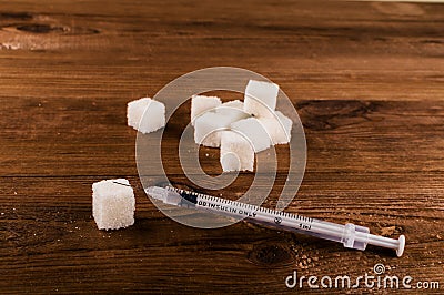 Diabetes is terrible disease. A lot of sugar cubes with syringe Stock Photo