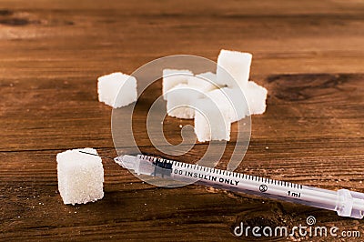Diabetes is terrible disease. A lot of sugar cubes with syringe Stock Photo