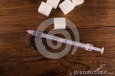 Diabetes is terrible disease. A lot of sugar cubes with syringe Stock Photo