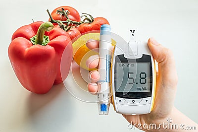 Diabetic diet, diabetes and healthy eating concept. Glucometer and vegetables. Stock Photo