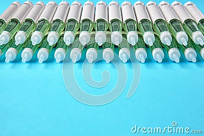 Diabetic insulin pens lined up on a blue background with copy space. Insurance coverage of medicines Stock Photo