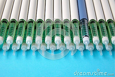 Diabetic insulin pens lined up on a blue background Stock Photo