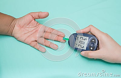 Diabetic patient measuring glucose with glucometer Stock Photo