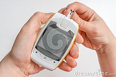Diabetic patient is using glucometer for measuring blood glucose level Stock Photo