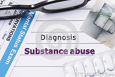 Diagnosis Substance Abuse. Medical notebook labeled Diagnosis Substance Abuse, psychiatric mental questionnaire and pills are on t Stock Photo